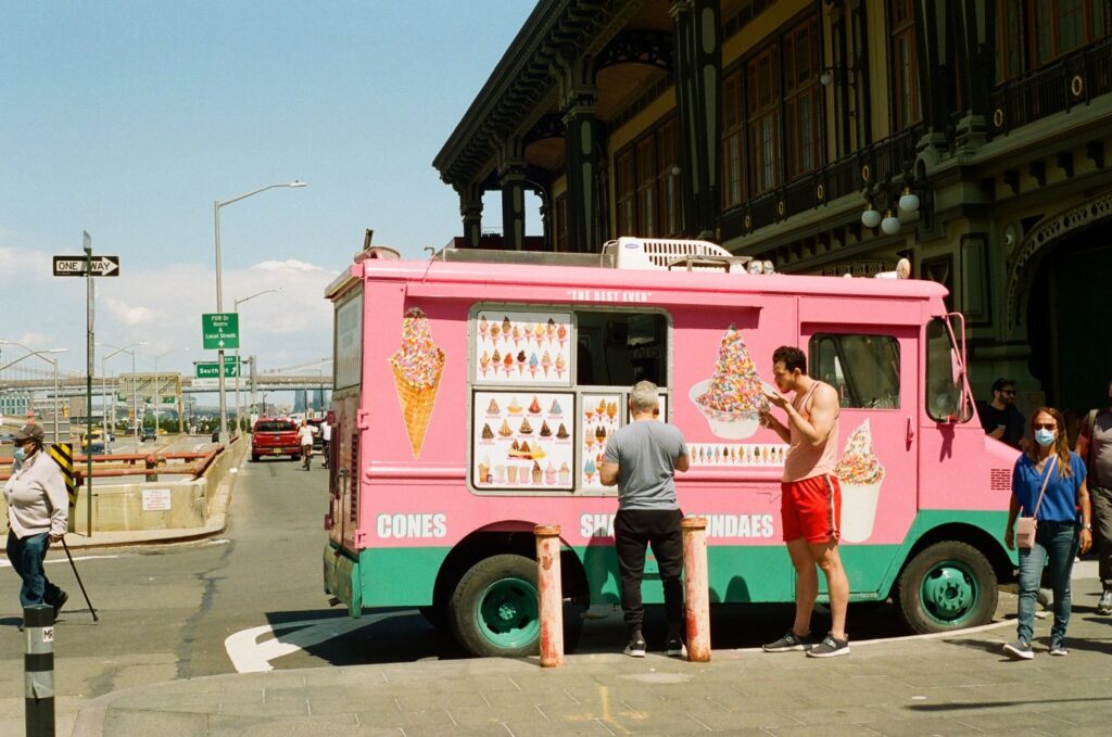 People eating Ice Cream in front of an Ice Cream truck